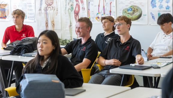 Boarding school seniors in a science class listening to the teacher