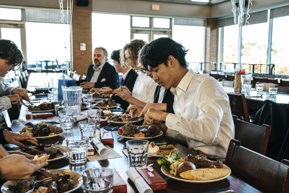 Private school students eating dinner in the dining hall after a day of activities