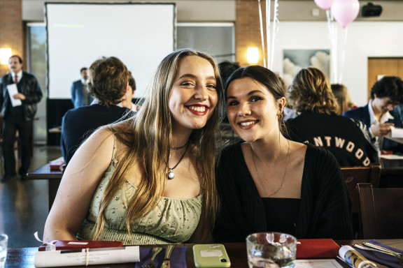 Two students smiling at dinner