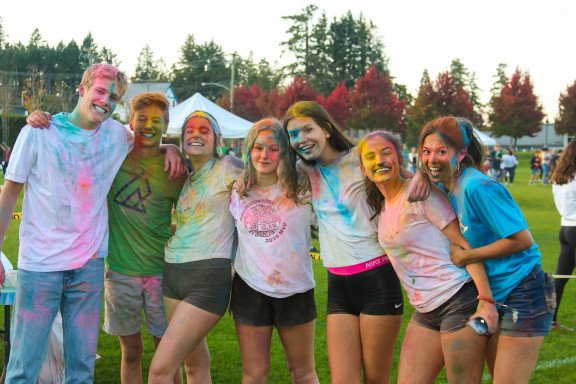 Students covered in paint smiling for a photo