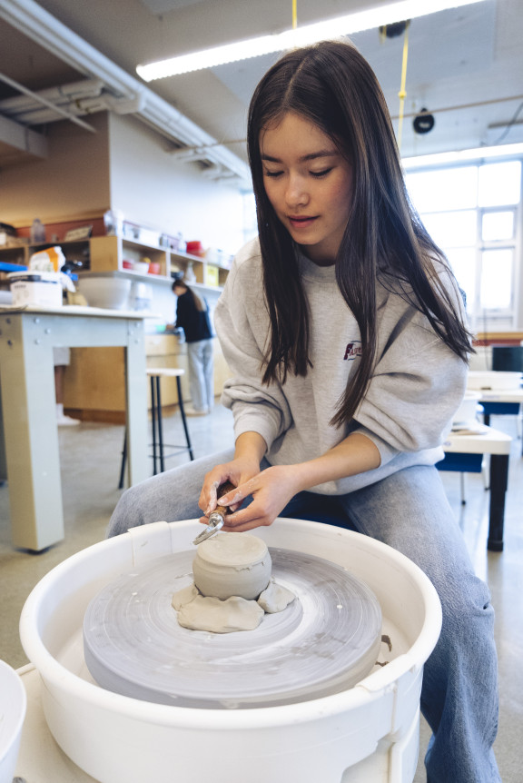 A student using the potting wheel