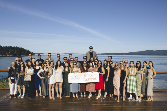 An alumni grad class posing for their ten year reunion photo