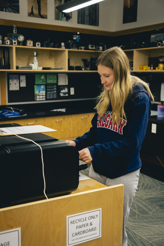 A student printing a photo on one of the studio printer