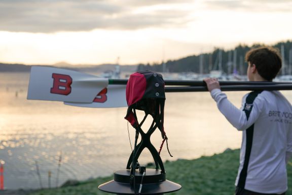 NeuroCatch cap device displayed with student rower in background