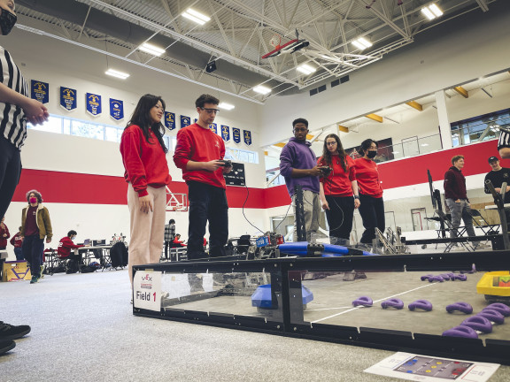 Two groups of robotics students at a competition