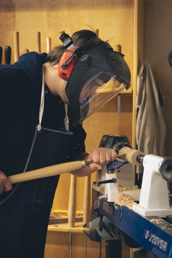 A woodworking students using the lathe