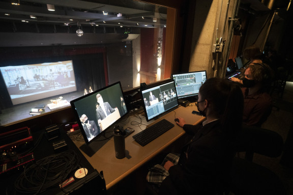 Students in the theatre booth work on computers