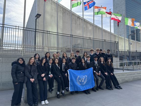 Male and female students proudly displaying the United Nations flag in New York