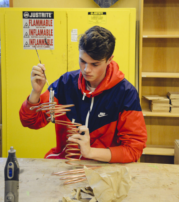 A student painting a 3D art sculpture