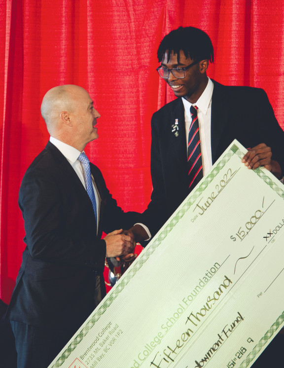 A Brentwood student presenting a cheque to the Director of Advancement