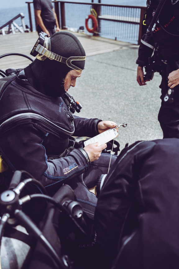 A student checking a list of diving items