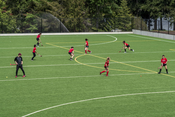 A field hockey practice with players passing the ball