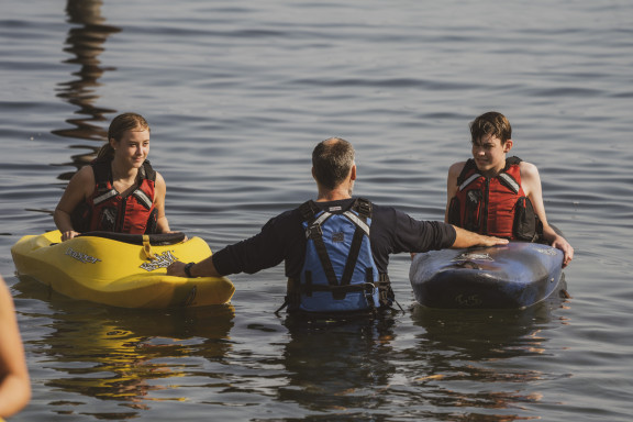 Two students learning how to kayak on the ocean