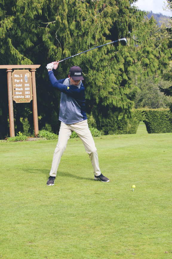 A golf student hitting the ball off the tee