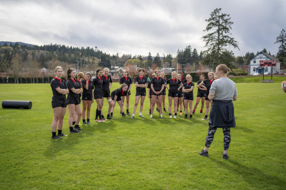 A group a rugby players listening to their coach