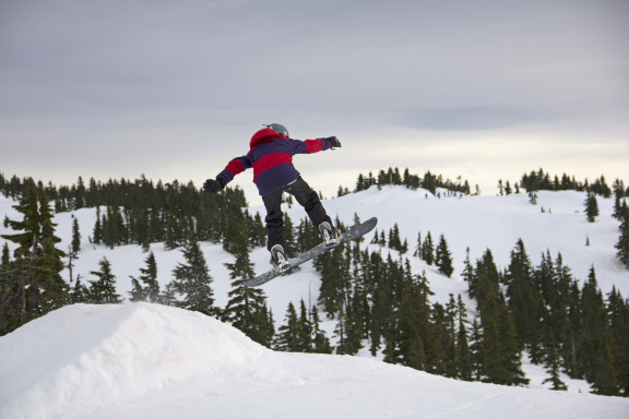 A snowboarder going over a jump