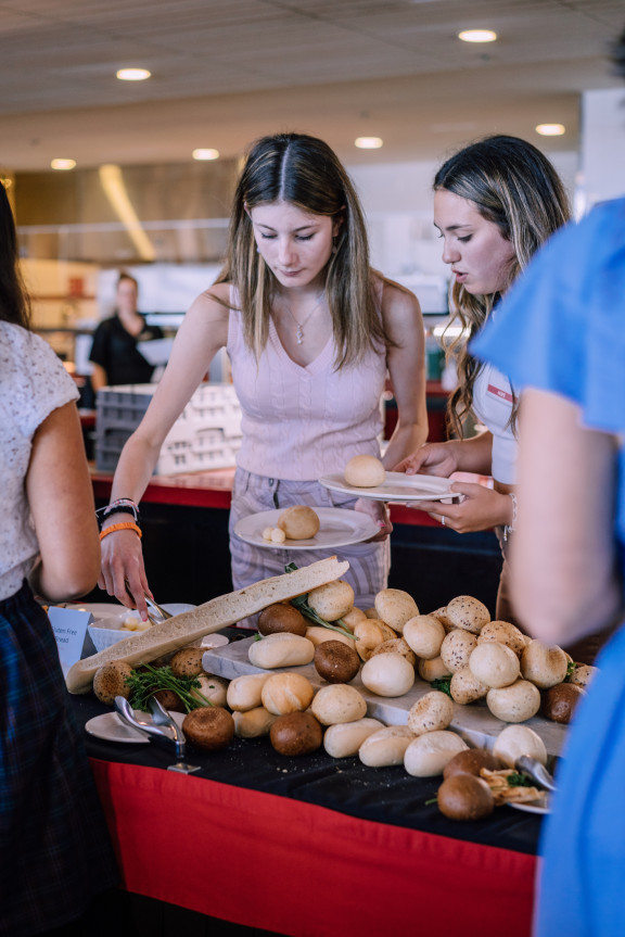 A student putting food on their plate during brunch