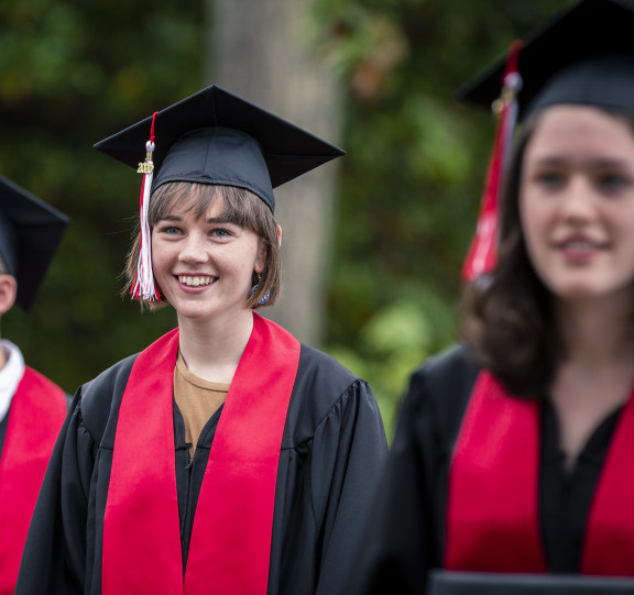 A graduate smiling at the year end ceremony