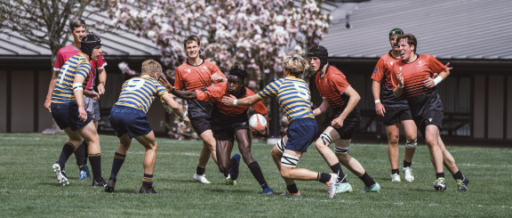 A rugby player driving forward with the ball