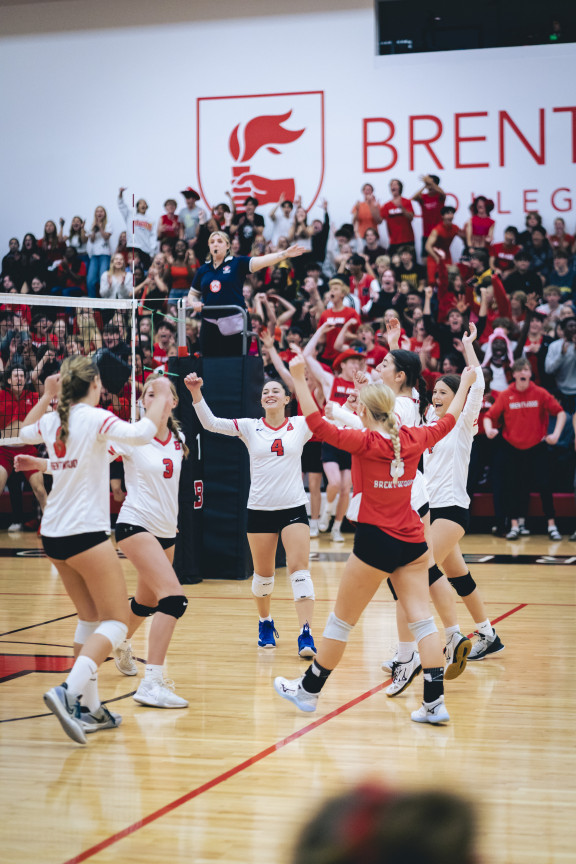 Volleyball players celebrating a point in the gym