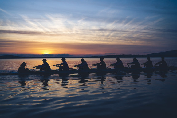 A sunrise with rowers out on the water