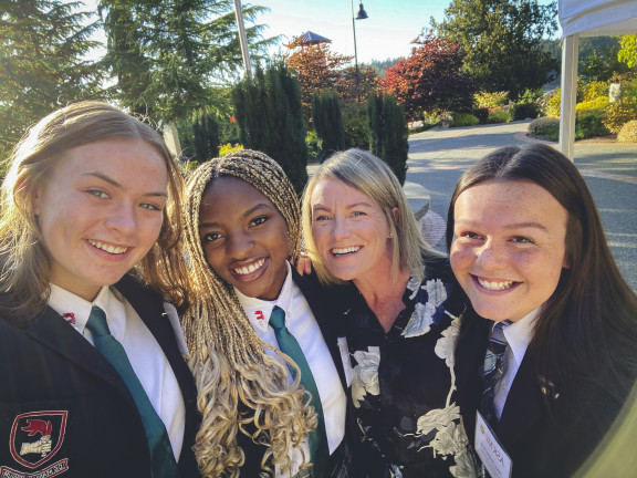 Three students taking a selfie with their house parent