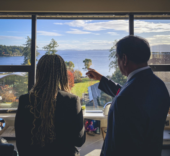 A staff member and student looking out the window