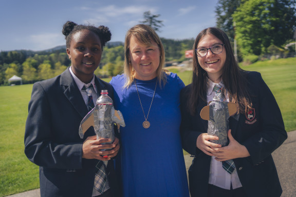 A teacher and two students with their science projects