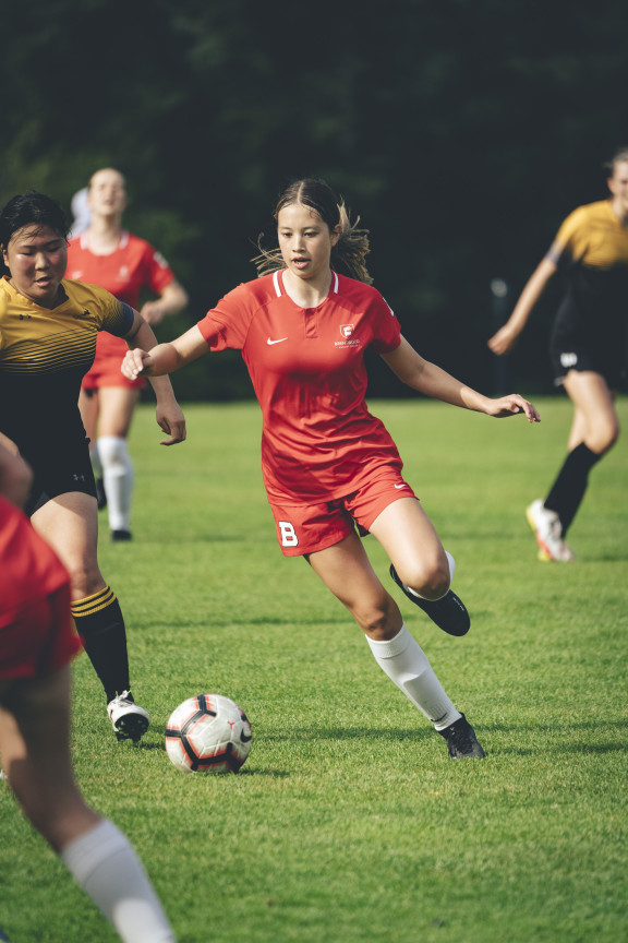 A soccer player running with the ball