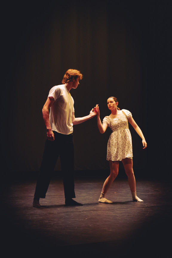 A duet between two dancers with dramatic lighting