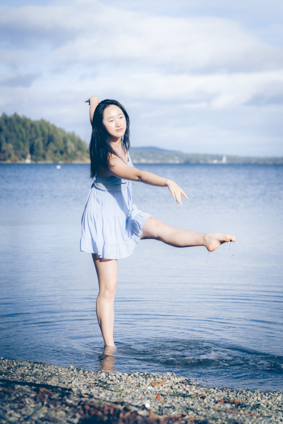 A dancer standing in the ocean pointing their toe