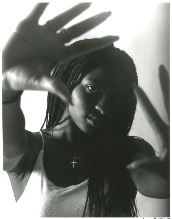 A black and white photo of a student holding their hands up in a frame