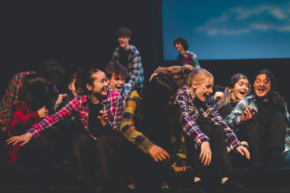 Students acting on stage smiling and having fun