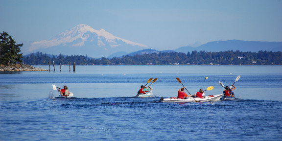 Kayakers on the water heading towards Mount Baker