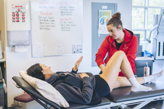 A student talking to an athletic therapist during a treatment