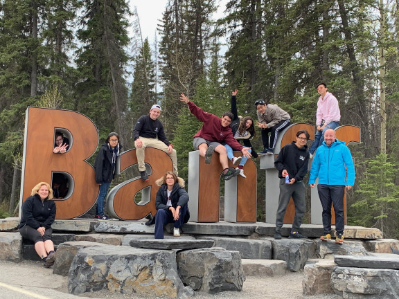Students climbing on the Banff sign