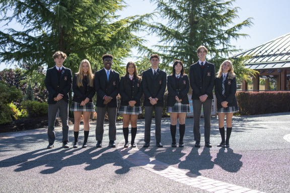 A group of students in uniform outside the theatre in the sun