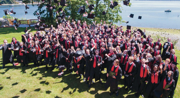 A graduating class celebrating the end of their graduation ceremony with a cap toss