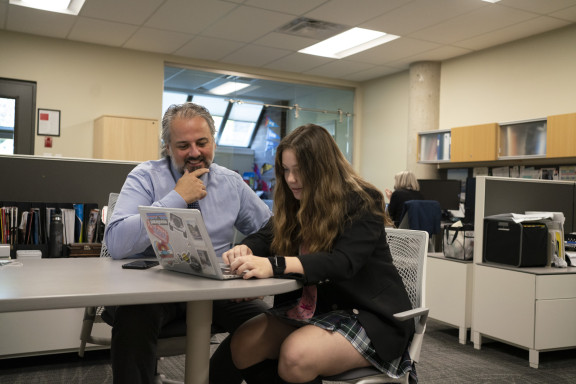 Mr. Rodrigues working with a student on applications.