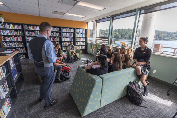 A teacher working with a class in the library