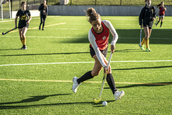 A field hockey player hitting the ball