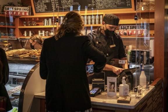 A staff member selling a coffee to a student