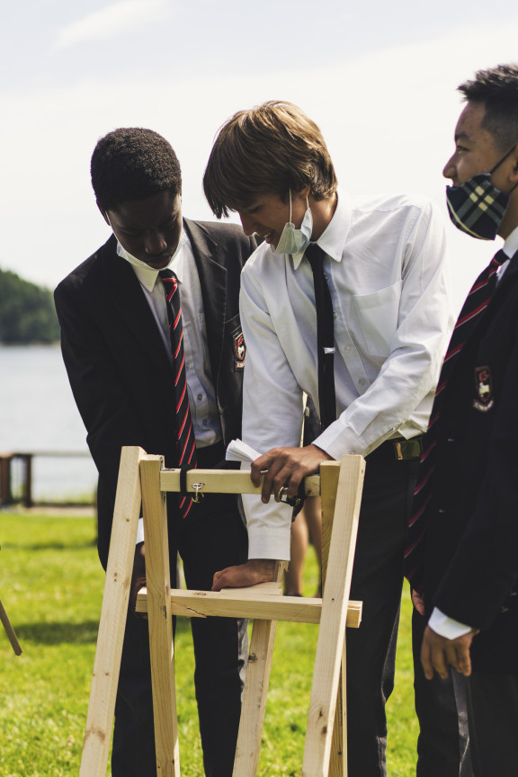 Two students building a homemade catapult