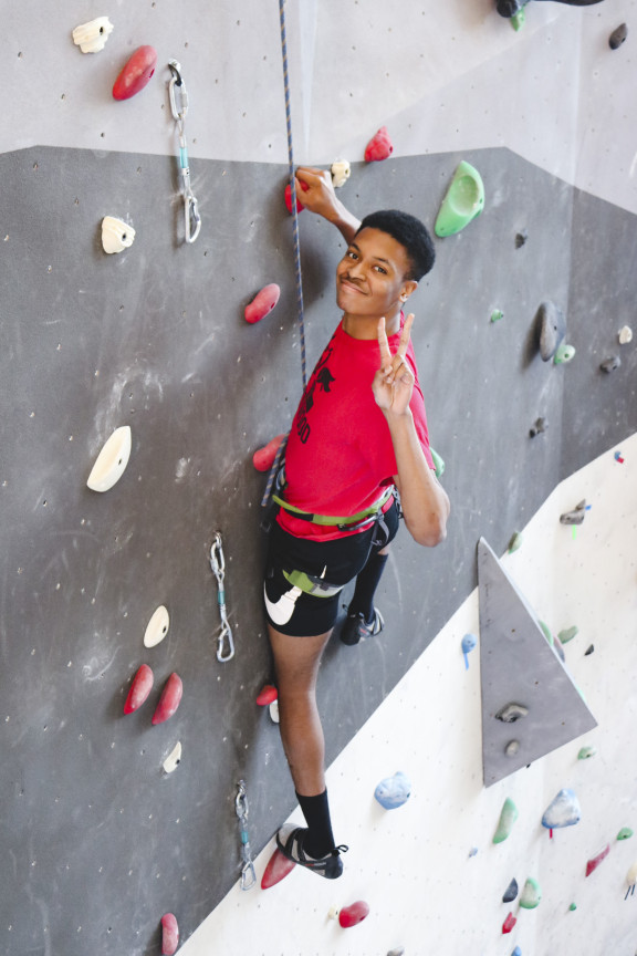 A student climbing the rock wall