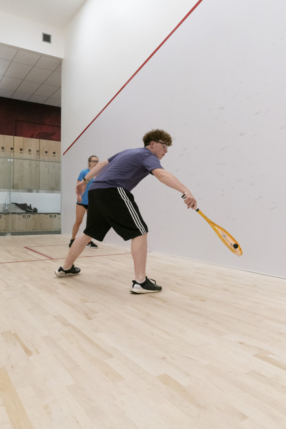 A squash player hitting the ball