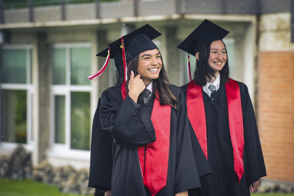 Two graduates smiling at the year end ceremony