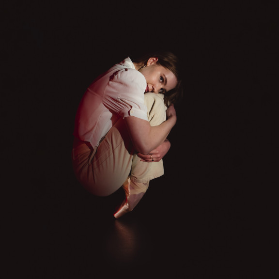 A dancer crouched down on the floor