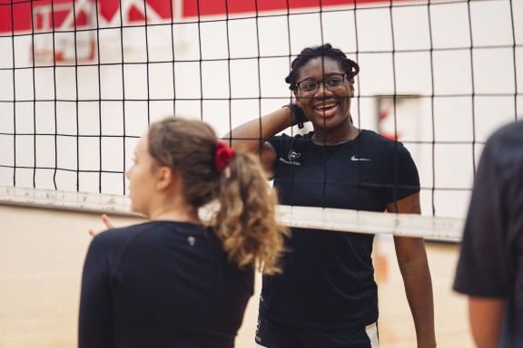 A student smiling while playing volleyball
