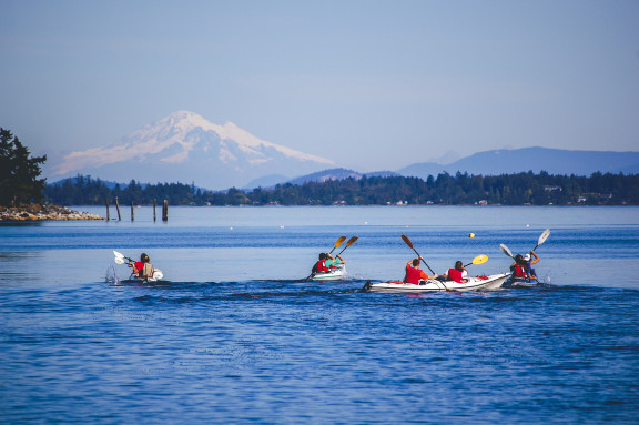 Students kayaking on the ocean with Mount Baker in the background