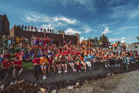 A large crowd of students sitting at the waterfront
